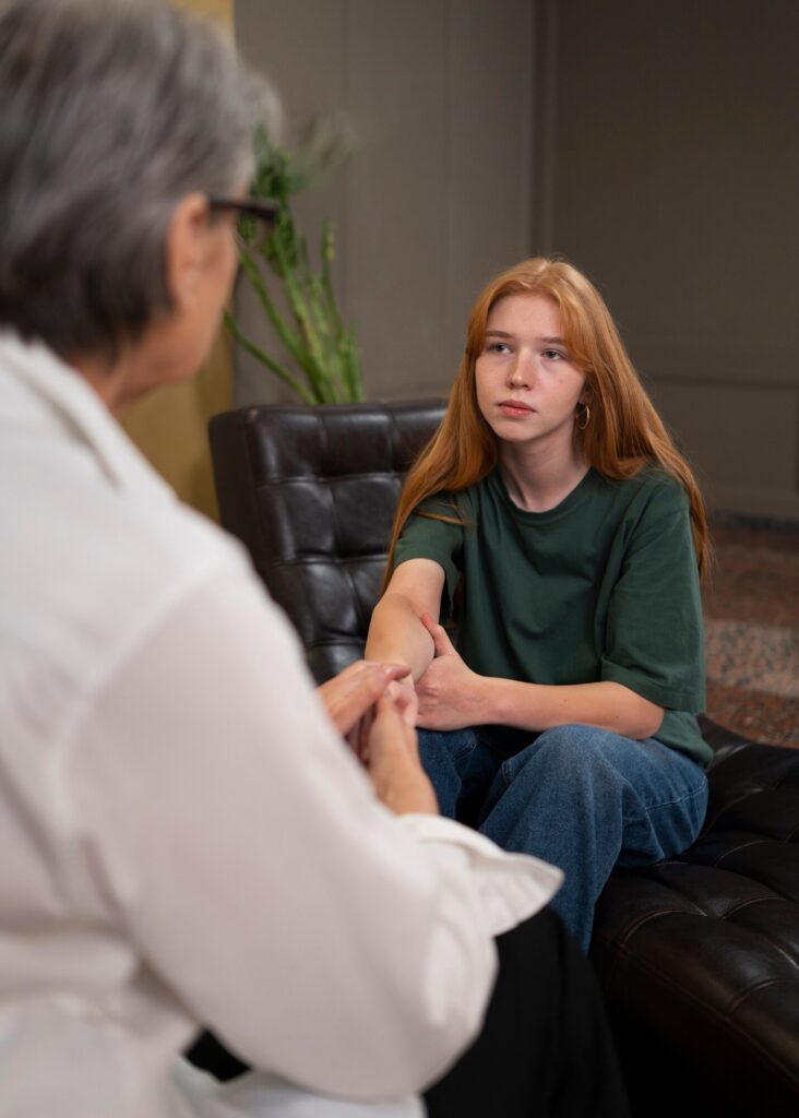 Teenager sitting on a chaise talking to a therapist