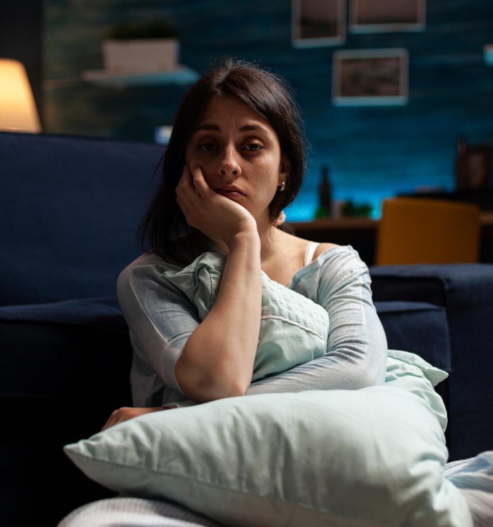 Woman sitting on the floor in front of a chair looking depressed